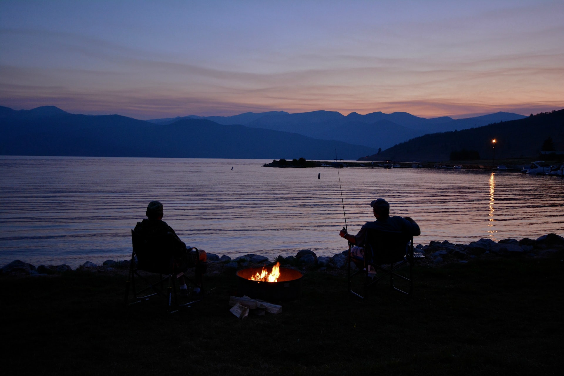 people with bonfire by the lake