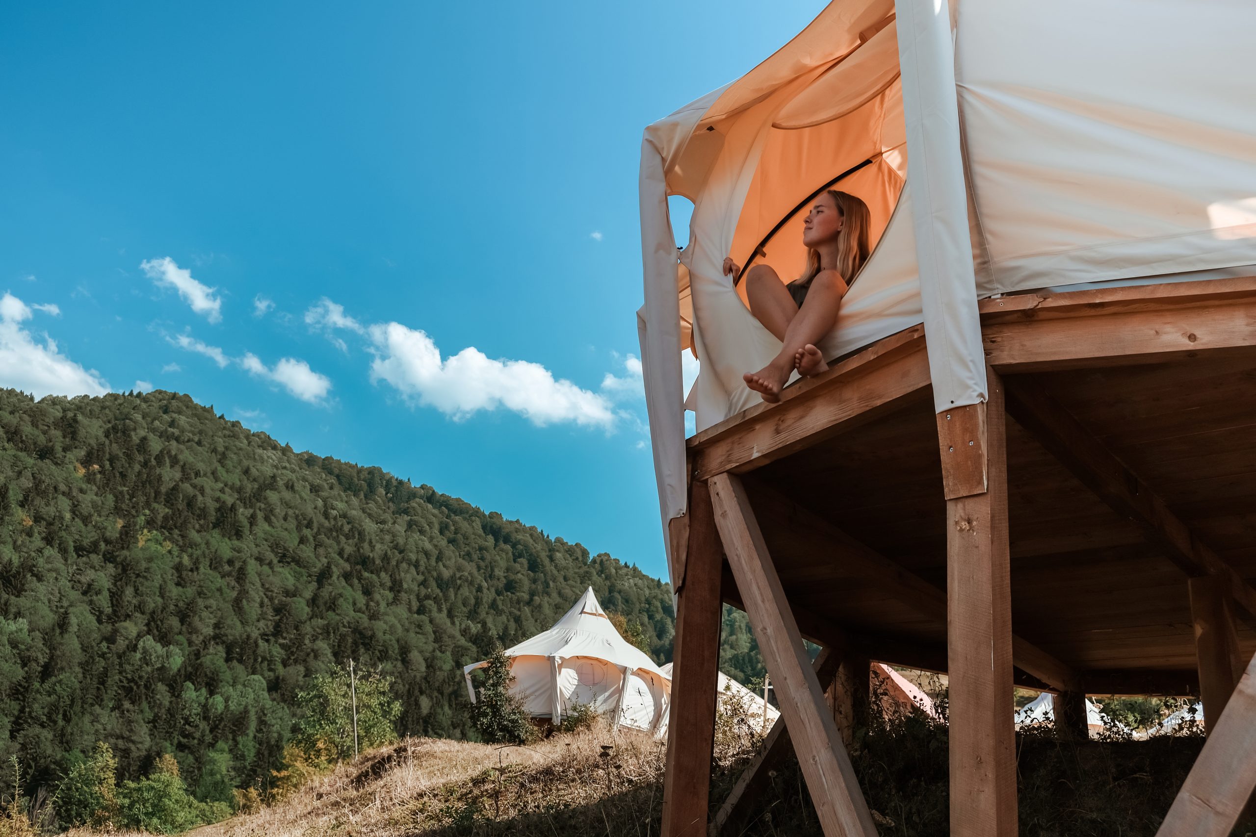 girl looking out from yurt in nc while camping