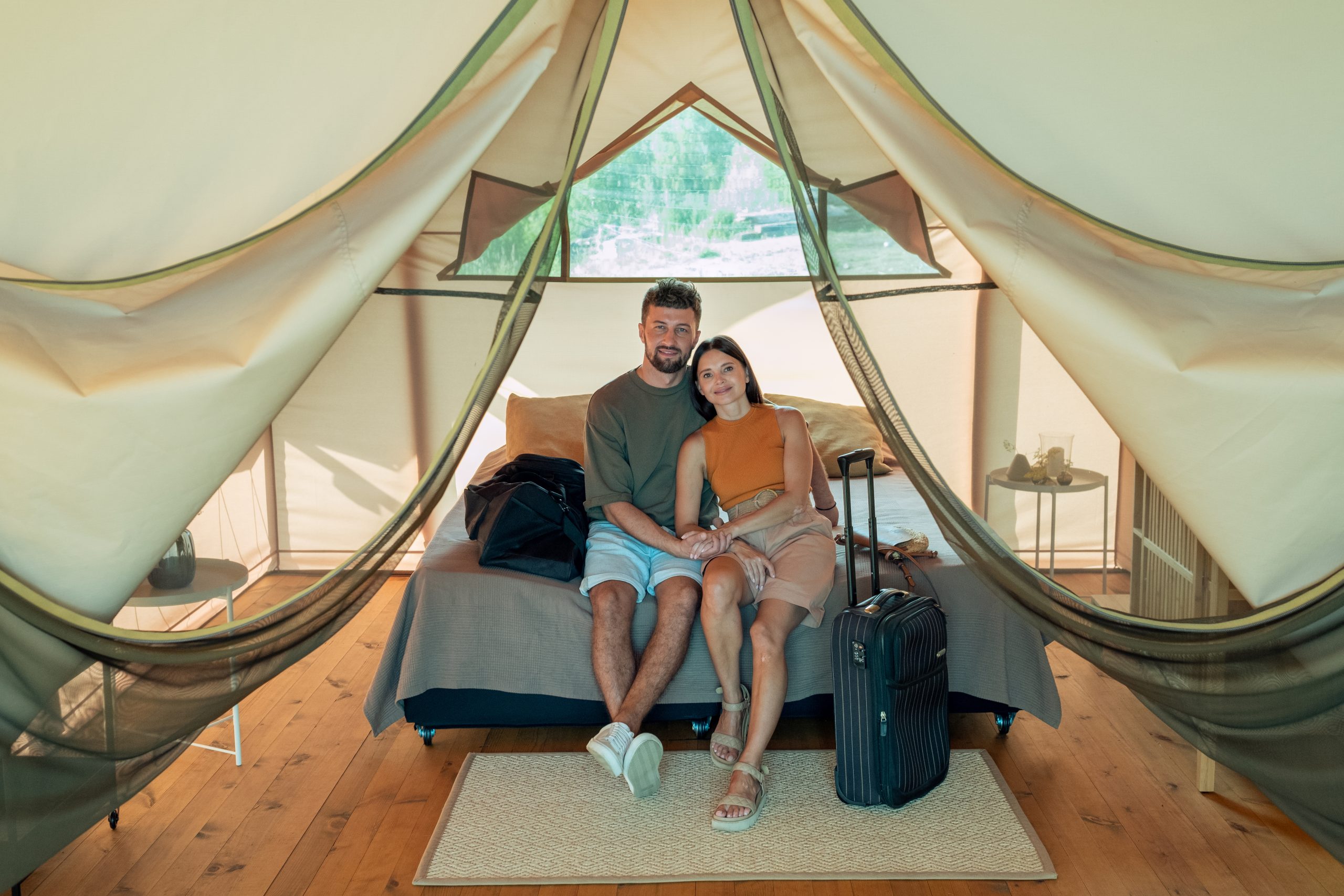 couple relaxing on bed inside a safari tent at a nc glamping site